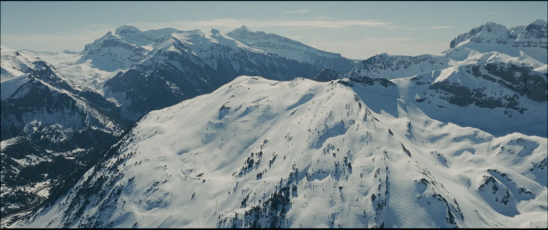 Cumbres nevadas del Pirineo aragonés sobre una estación de esquí